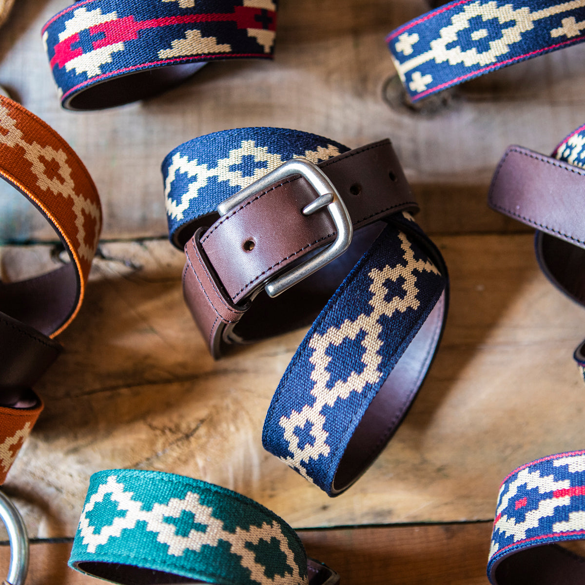 Brown leather belt with a navy and beige geometric woven pattern.