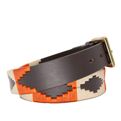 A brown leather belt with a burnt orange and khaki woven geometric pattern and solid brass buckle.