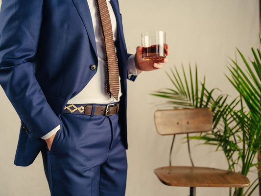 Brown leather belt with a navy and beige geometric woven pattern.