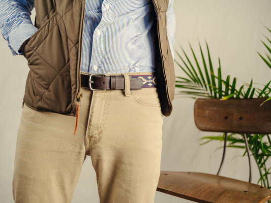 A brown leather belt with a Navy, Red, and Khaki woven geometric pattern and solid brass buckle.