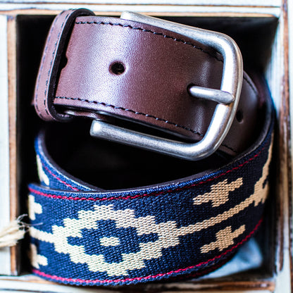 A brown leather belt with a Navy, Red, and Khaki woven geometric pattern and solid brass buckle.