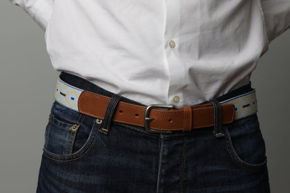 A brown leather belt with a light blue and beige woven pattern and metal nickle buckle.
