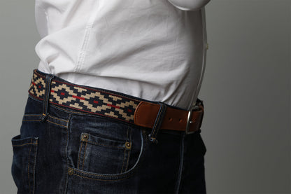 A cognac brown leather belt with a navy, kahki and red woven geometric pattern and solid brass buckle.